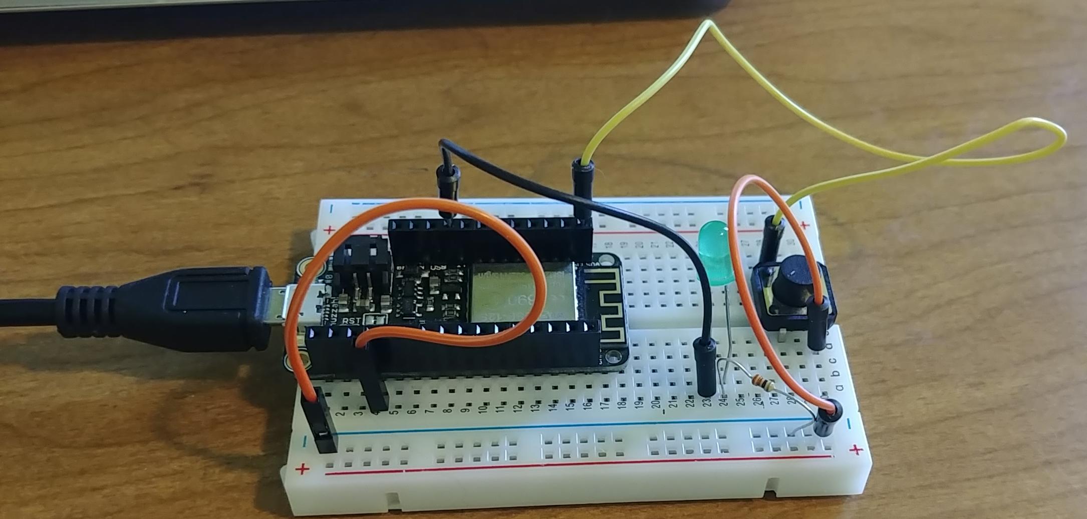 Adafruit Feather Huzzah on a breadboard with a switch, LED, a resistor, and some wires